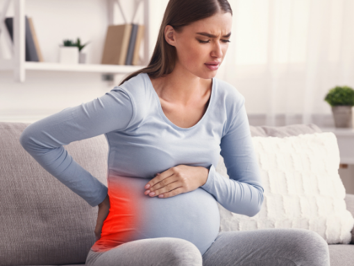 Pregnant woman sitting uncomfortably with pelvic girdle pain