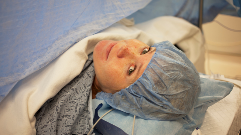 Woman under surgical drape in the OR